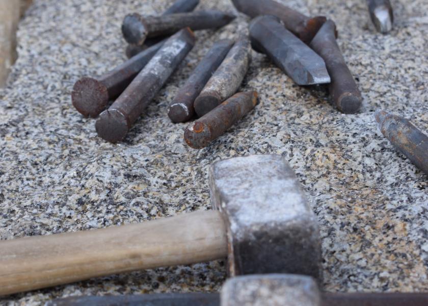 Alte Hammer und Nägel liegen auf einem Kiesbett