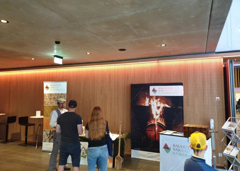 Projektstand zu traditionellen Handwerkstechniken, ein Mann am Stand spricht mit zwei Besuchern