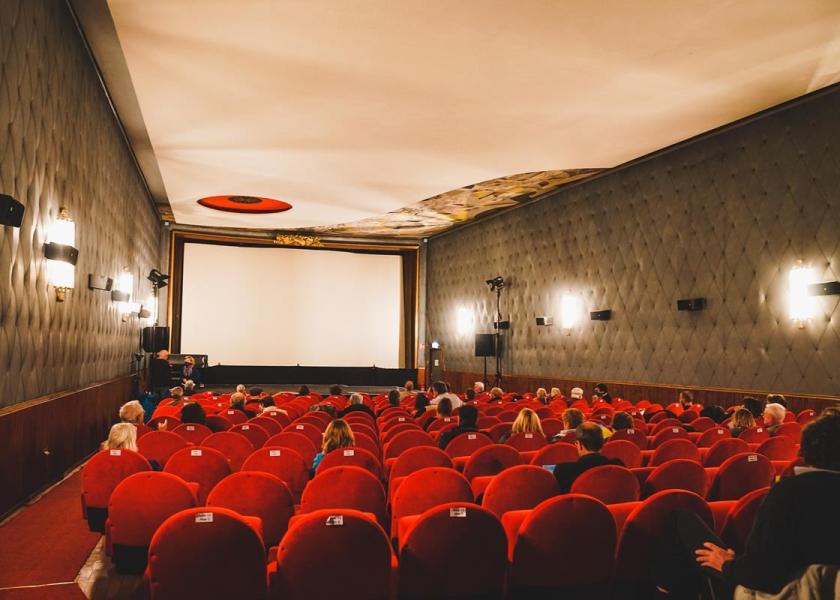 Kinosaal mit Leinwand und roten Sesseln