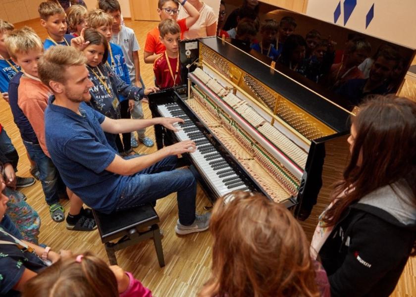 Mann spiel Klavier und Kinder sehen zu