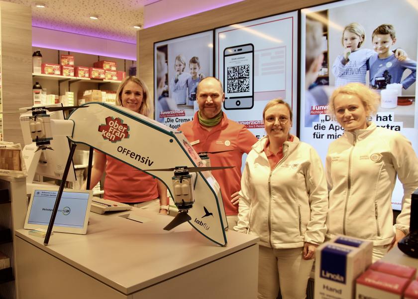 Vier Personen mit Drohne in einer Apotheke 