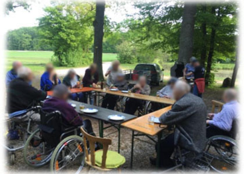Gruppe von Senioren sitzen rings um Biertischen