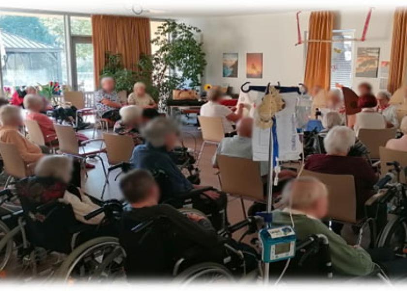 Bewohner des Seniorenheims sitzen in Gemeinschaftsraum 