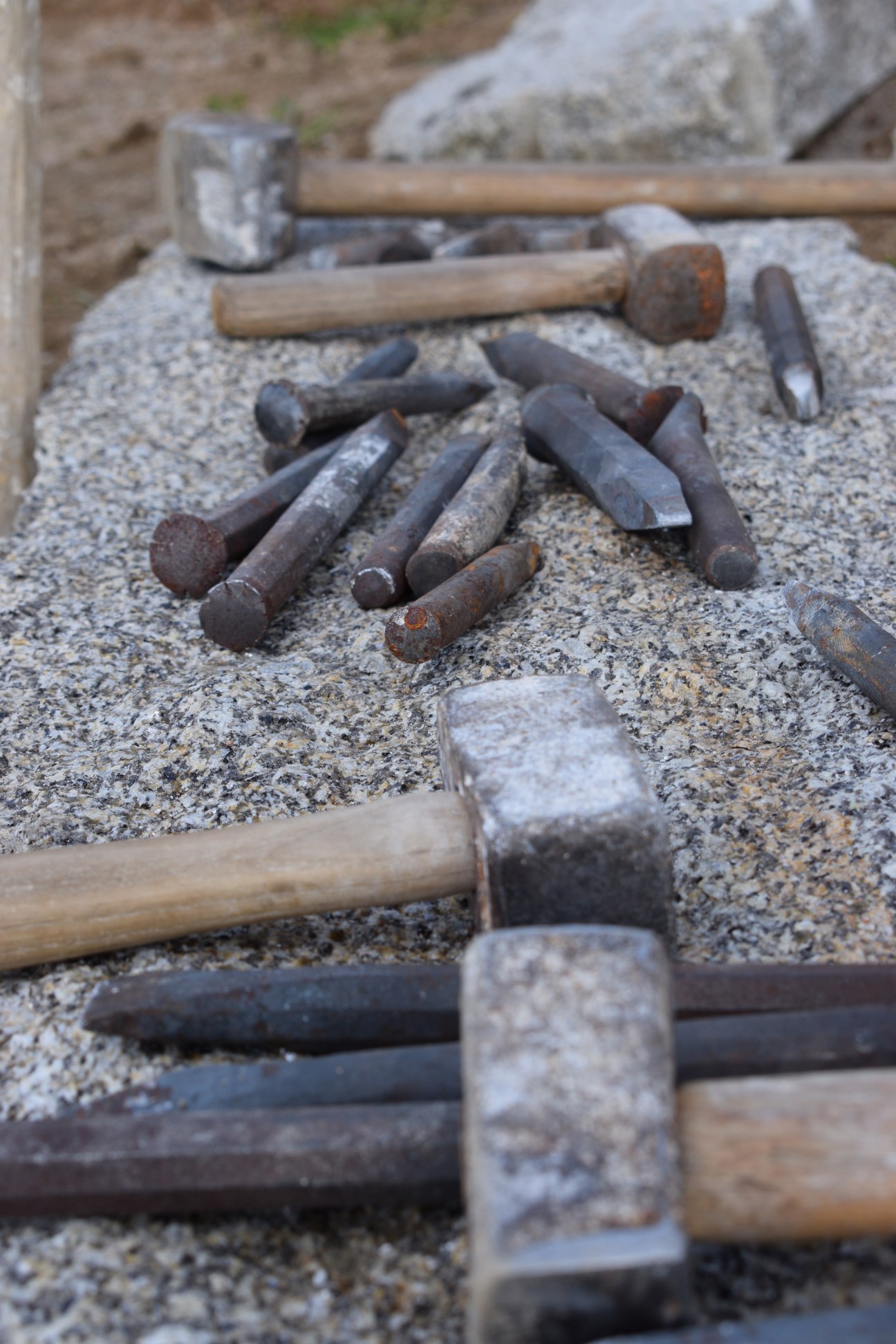 Alte Hammer und Nägel liegen auf einem Kiesbett