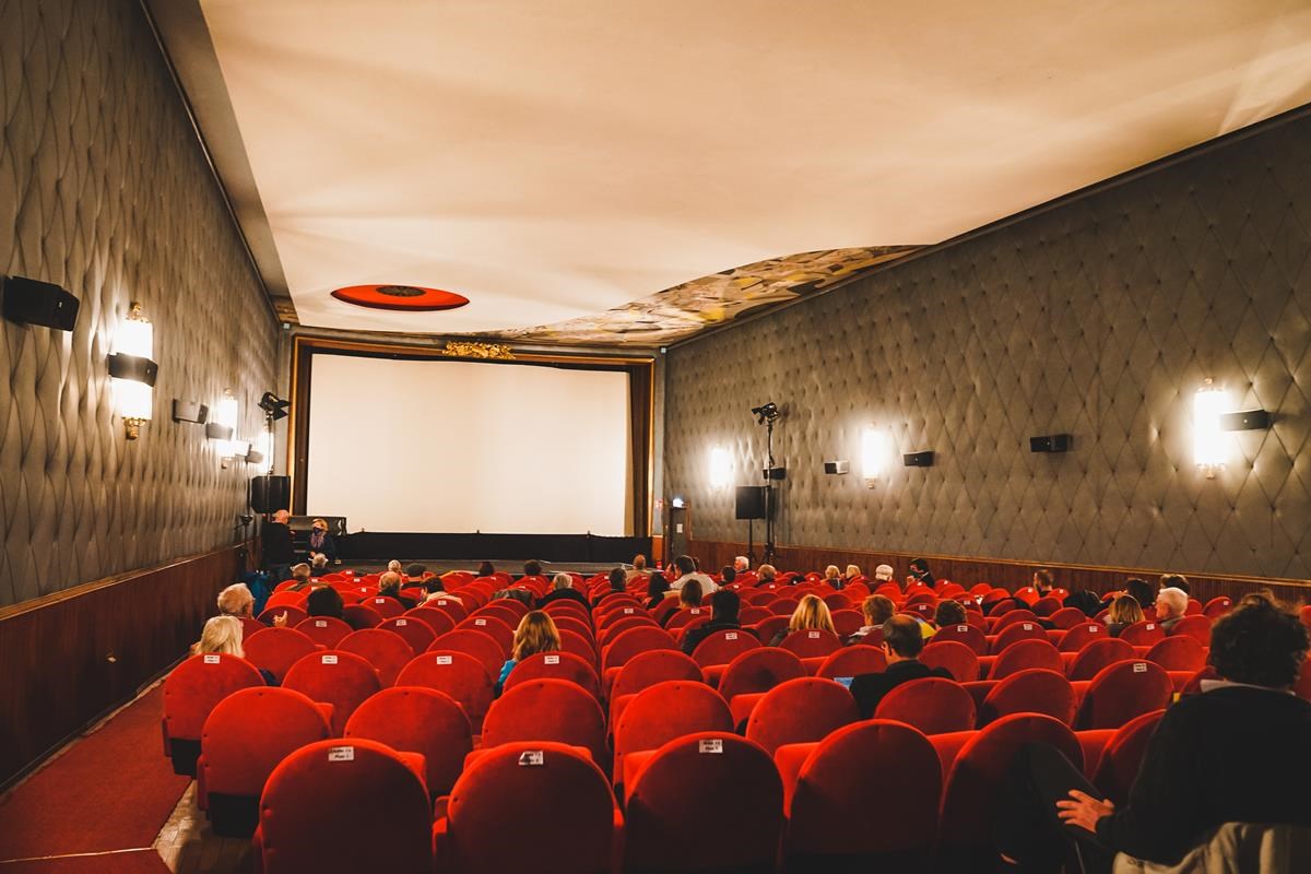 Kinosaal mit Leinwand und roten Sesseln