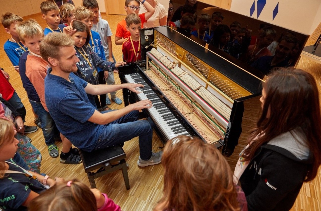 Mann spiel Klavier und Kinder sehen zu 