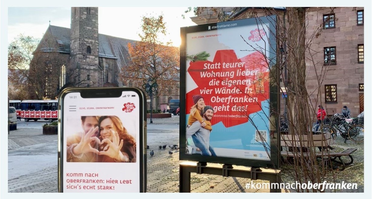 Werbeplakat für Oberfranken mit Handy, digitalen Stelle und im Hintergrund eine oberfränkische Stadt